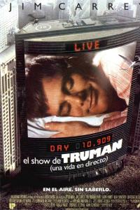 Paisaje urbano con una gran pantalla digital en un edificio que muestra a un hombre durmiendo, con la leyenda "EN VIVO, Día 10.909, el show de TRUMAN". 